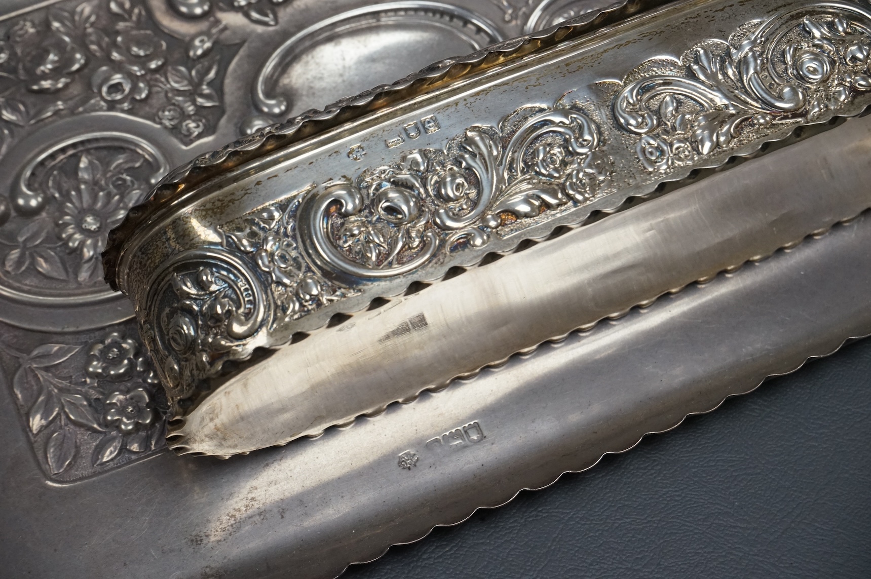 An early 20th century repousse silver dressing table tray by William Comyns & Sons Ltd, London, 1901, 25.1cm, together with a matching oval trinket box, London, 1900, 16.6oz (a.f.).